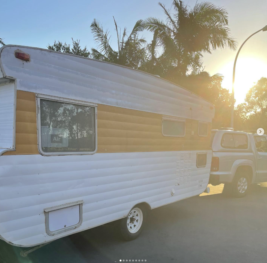 Orange and white caravan before restoration at sunset